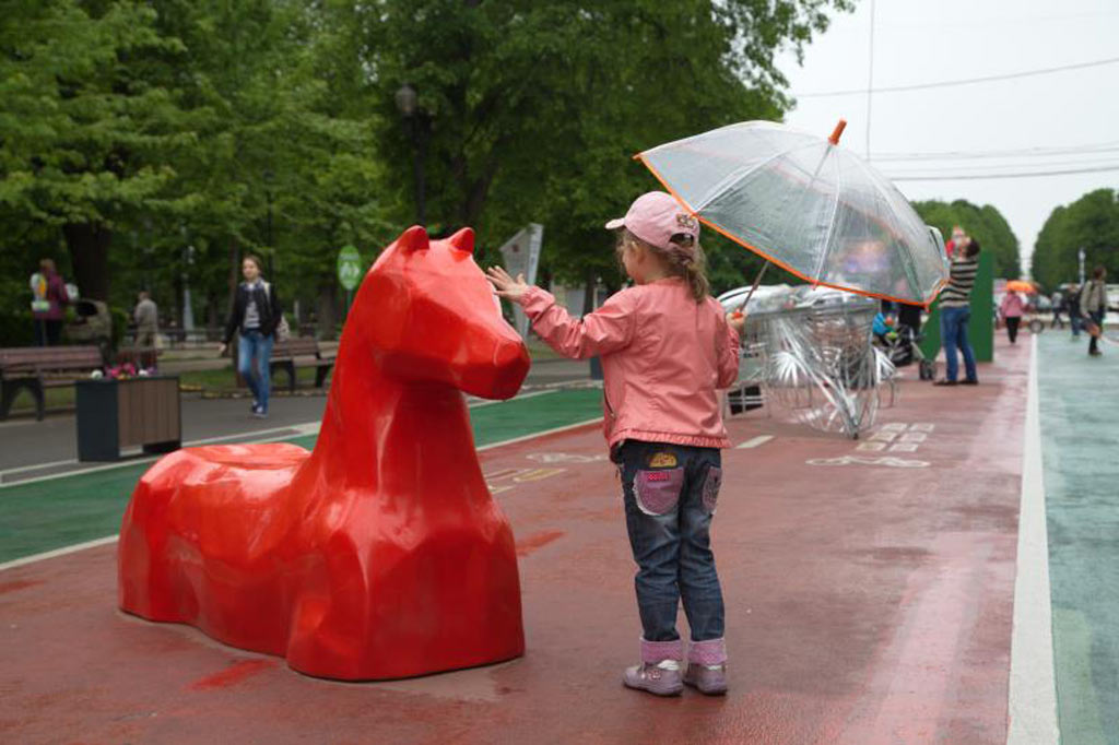 дизайн красного коня - скамейки на дне города, посреди пешеходной зоны