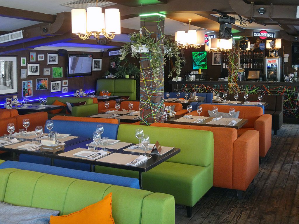 Обеденный зал ресторана, разноцветная мебель, яркие фото, цветной паракорд.