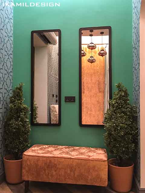 боковая бирюзовая стена с зеркалами и пуфами в гардеробе чайханы
